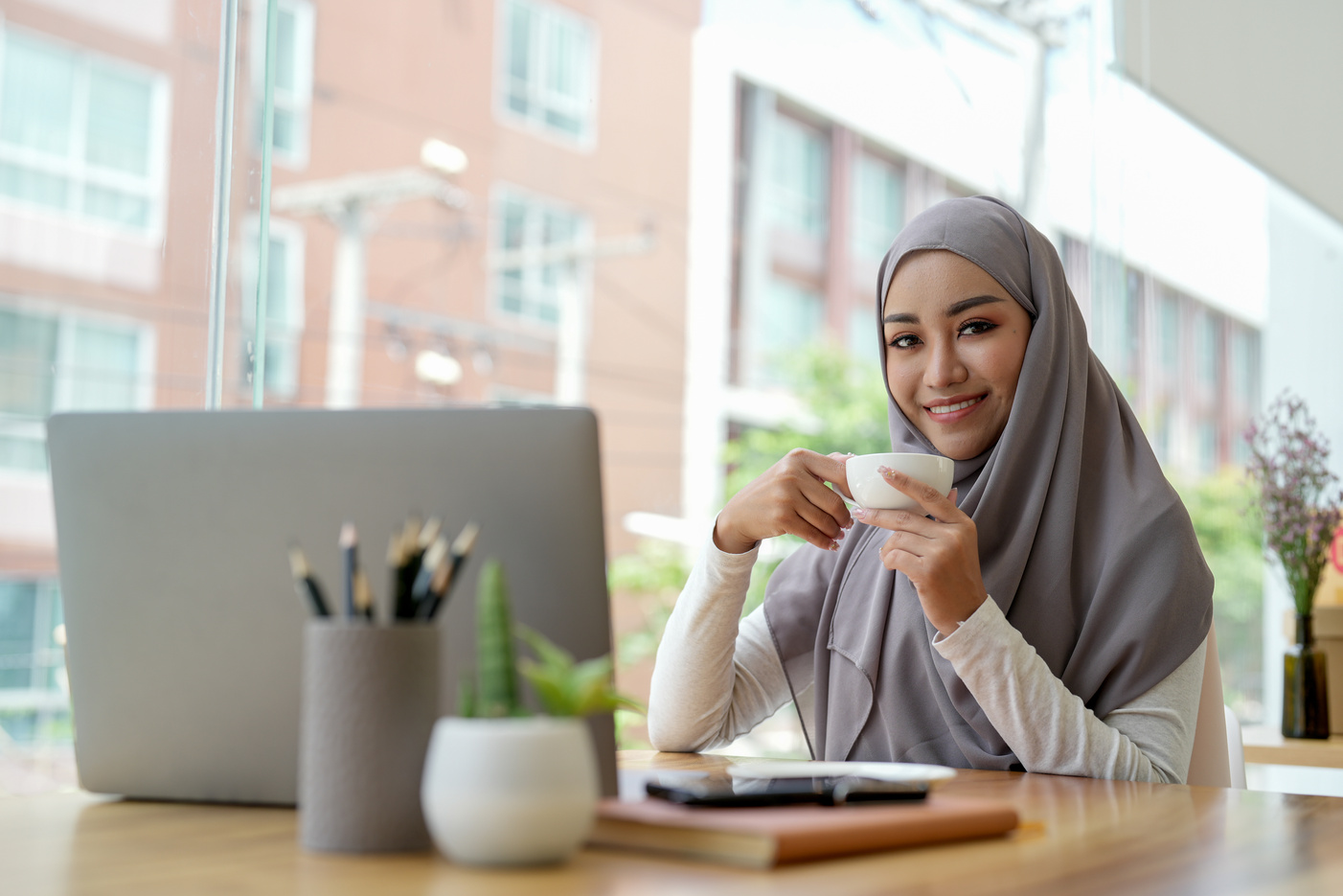 Attractive muslin woman working in office with laptop comput